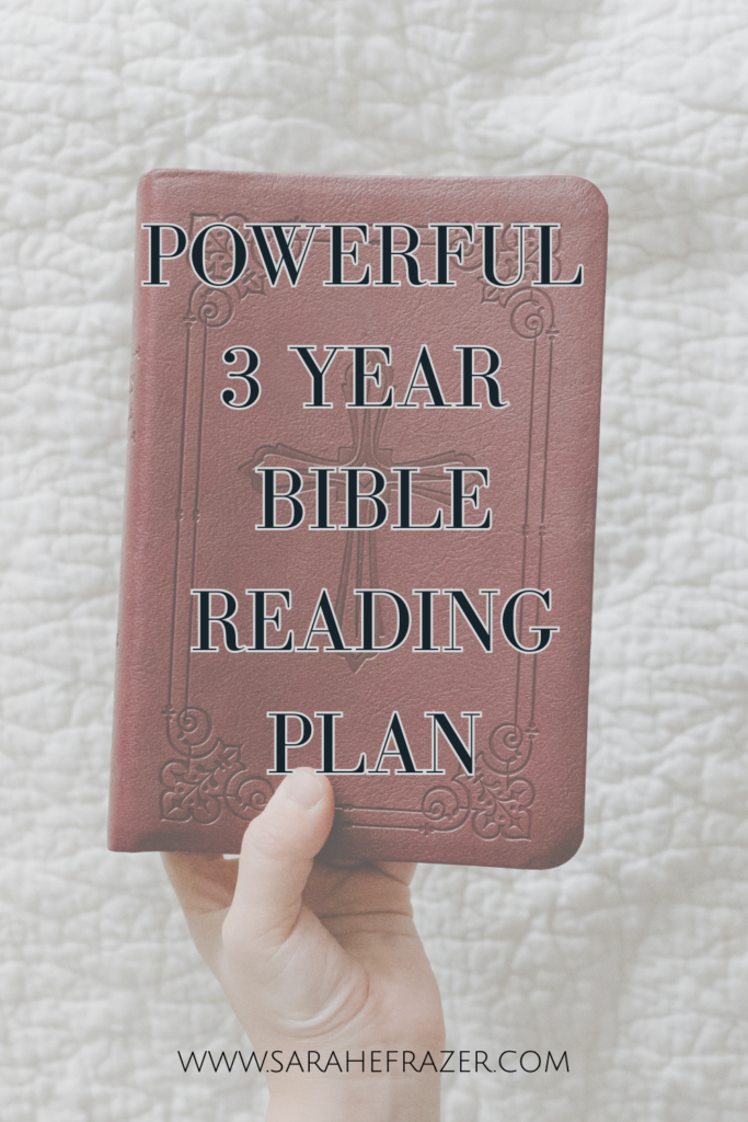 Womans hand holds up a small brown Bible with a cross stamped on it. Text overlay reads "powerful 3 year Bible reading plan"