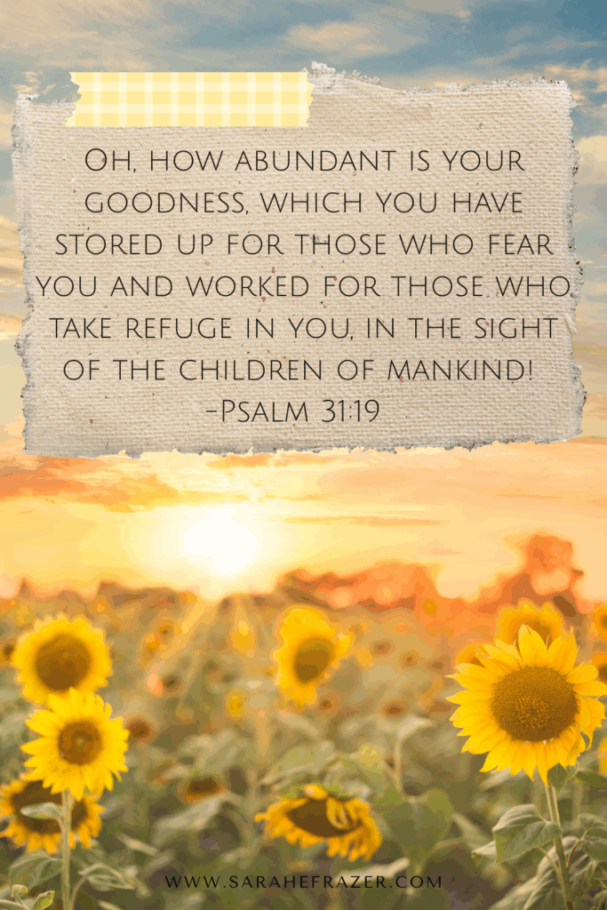 Psalm 31:19 Bible verse on a scrap of paper taped over a photo of a sunflower field at golden hour