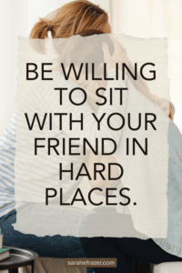 two friends hug each other while sitting on a bed. Text overlay is a quote about friendship and supporting friends in grief