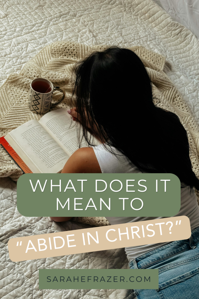 Woman lays on her belly on a blanket reading. a book. Text overlay reads: what does it mean to abide in christ