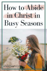 woman has her arms full of flowers walking in a field "how to abide in christ in busy seasons"