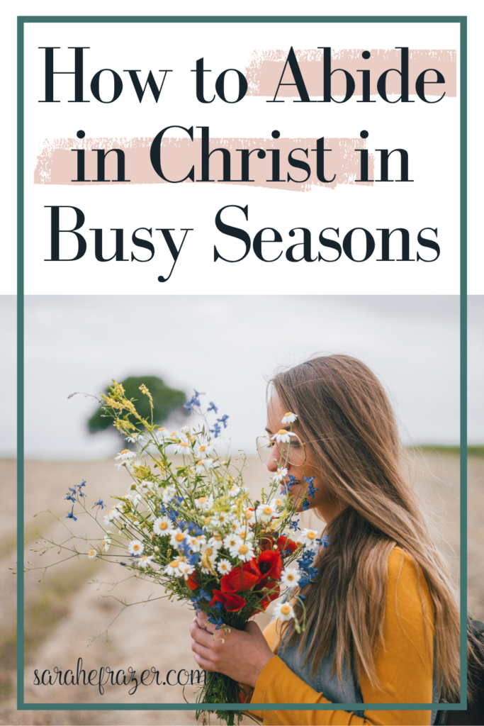 woman has her arms full of flowers walking in a field "how to abide in christ in busy seasons"