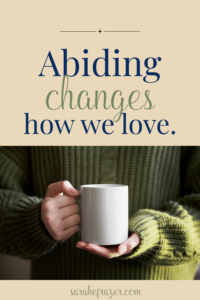 image with a woman in a chunky green sweater holding a white coffee mug. Text reads: Abiding changes how we love