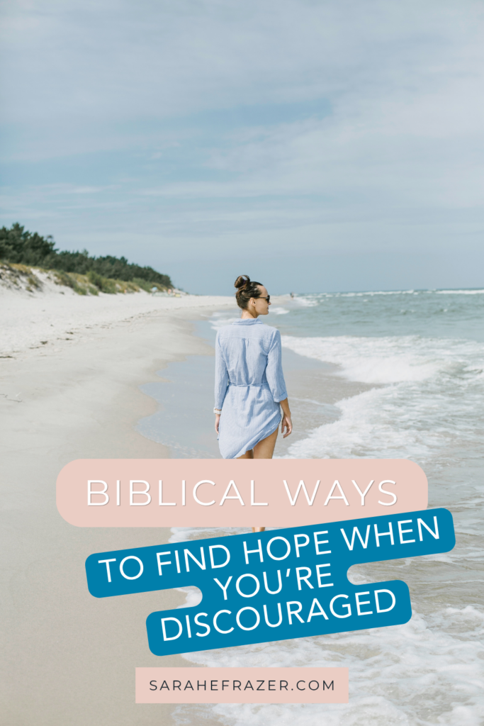 woman walks on beach with text overlay find hope when you're discouraged